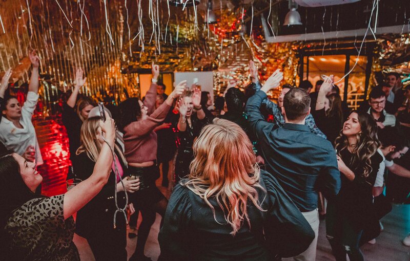 Das Bild zeigt eine Gruppe Menschen, die zusammen auf einer Tanzfläche feiern. Die Stimmung ist ausgelassen. Glitzernde Girlanden hängen von der Decke. | © wob AG
