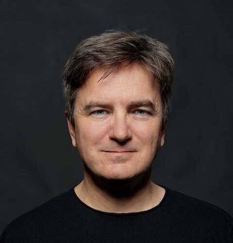Dieses Bild ist ein Porträt von Matthias Specht. Er trägt ein schwarzes Shirt. Der Hintergrund ist dunkel. | © wob AG
